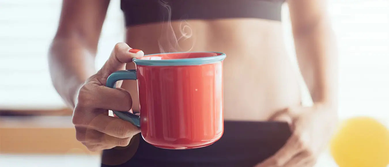 Eine Frau in Sportbekleidung hält einen Kaffee Becher der Kaffeerösterei Martermühle in die Kamera