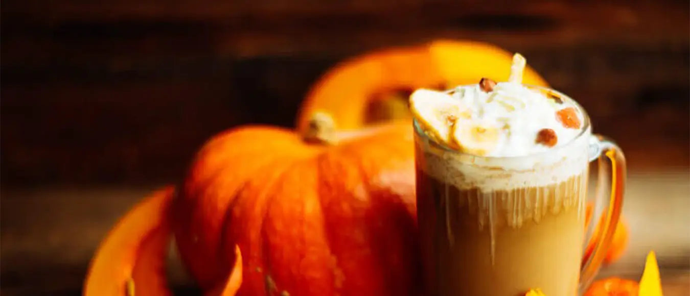 Ein großer Kürbis und ein Kaffee mit Sahnehaube