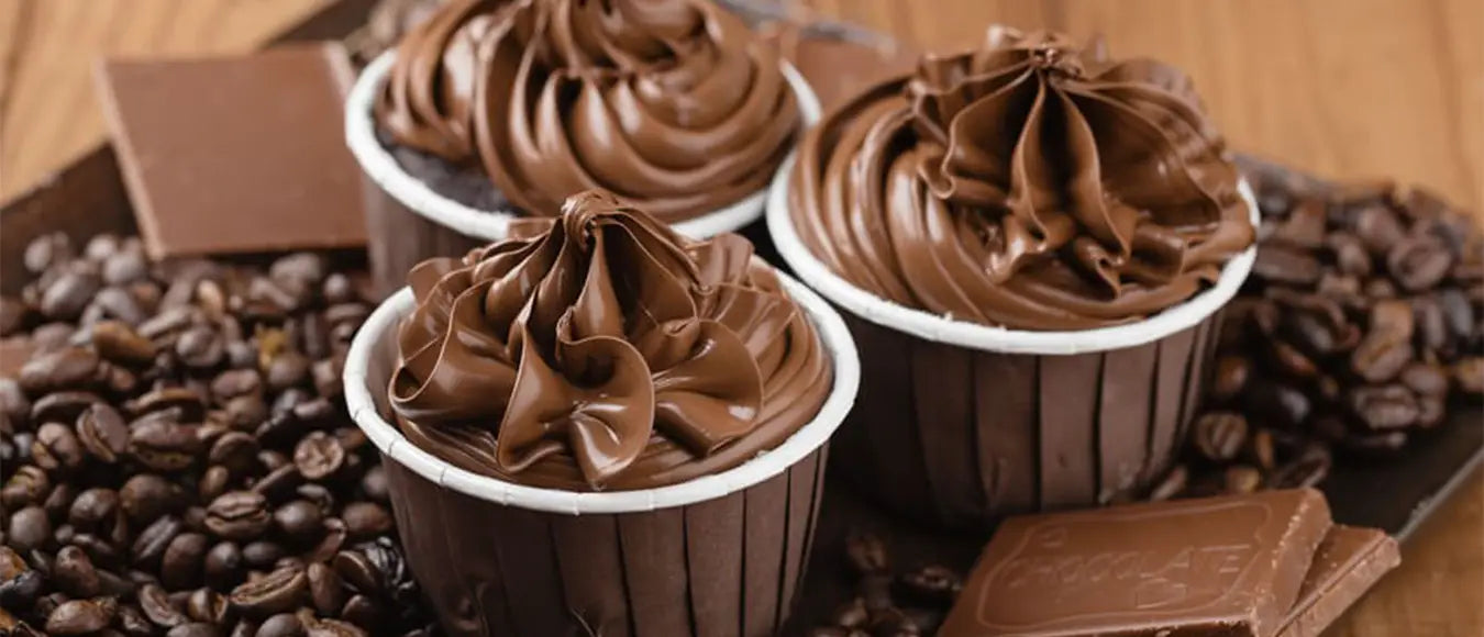 Drei Schokotörtchen zwischen Kaffeebohnen der Kaffeerösterei Martermühle