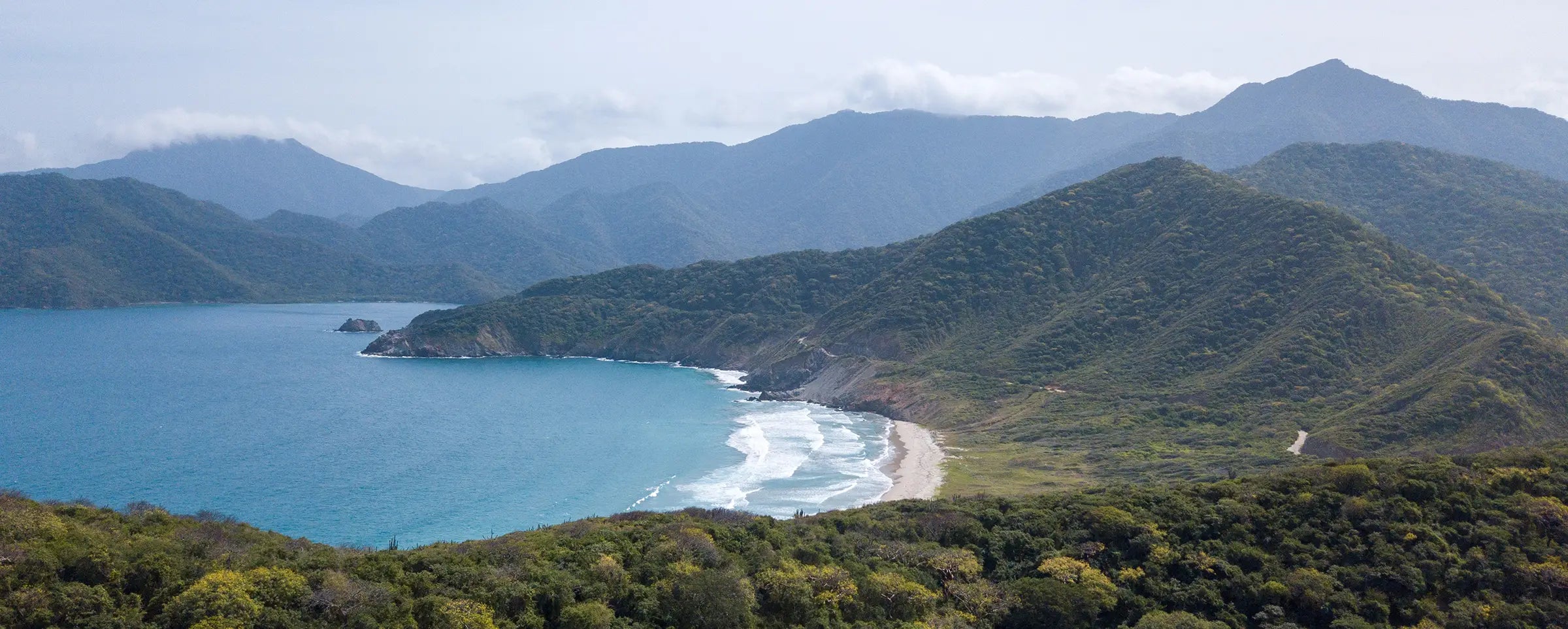 Luftaufnahme einer Küstenregion in Kolumbien mit einer Bucht umringt von Bergen