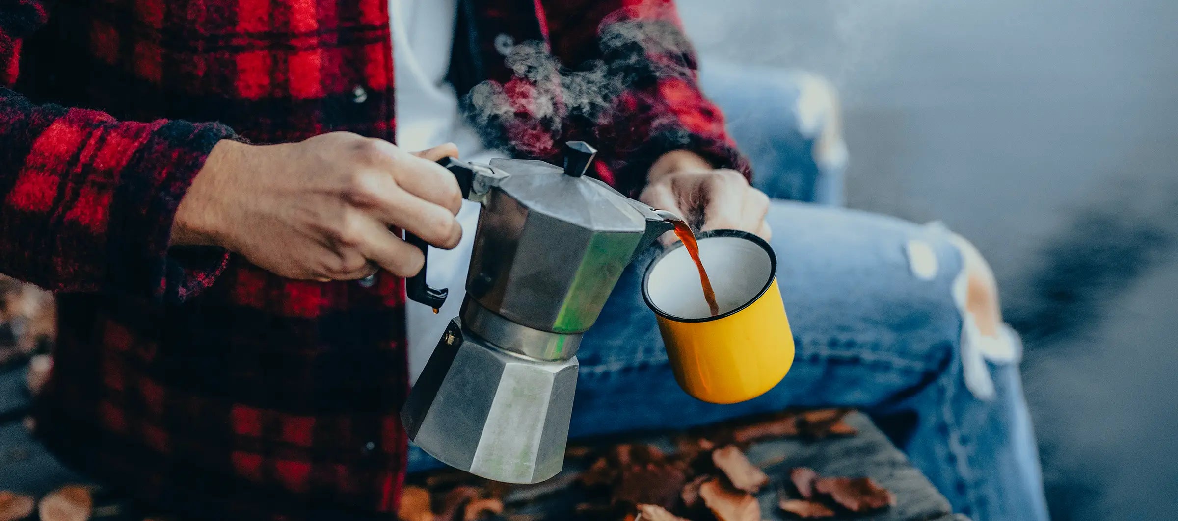 Jemand gießt Espresso aus einer Stempelkanne in einen Emaille Becher der Kaffeerösterei Martermühle