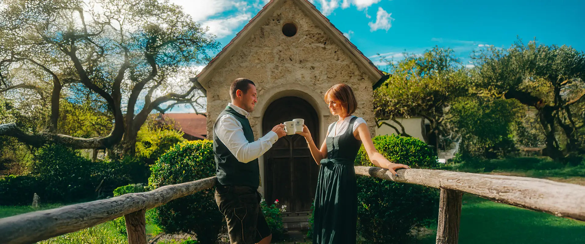 Junges Pärchen in Tracht mit zwei Tassen Martermühle Kaffee.