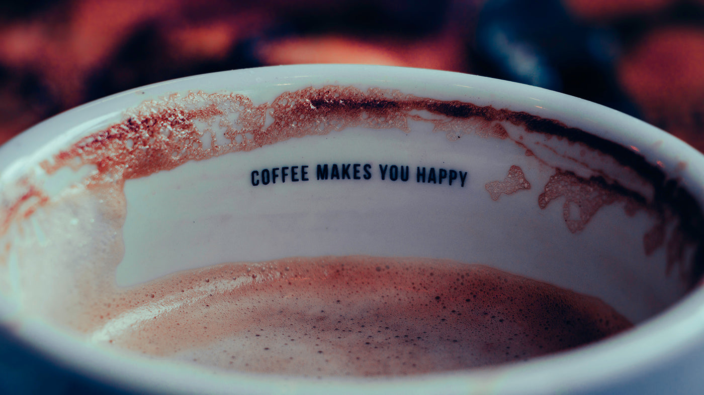 Das Innere einer Kaffeetasse mit der Aufschrift "COFFEE MAKES YOU HAPPY"