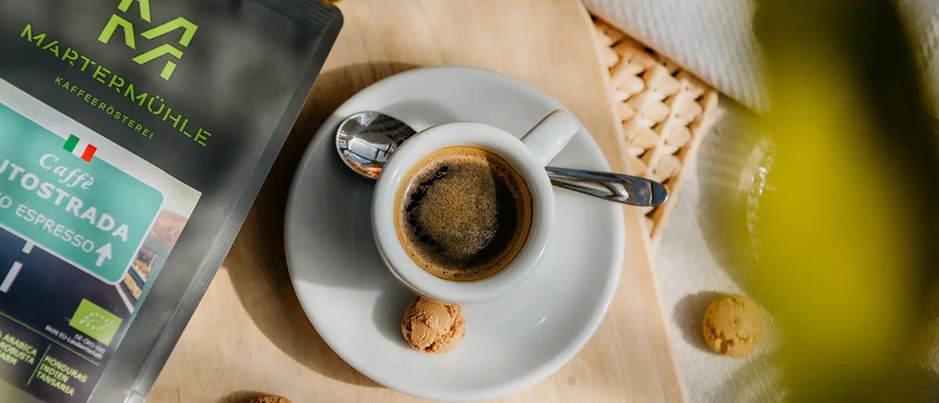 Top View einer Espressotasse mit frischem Espresso und einer Tüte Bio-Espresso der Kaffeerösterei Martermühle