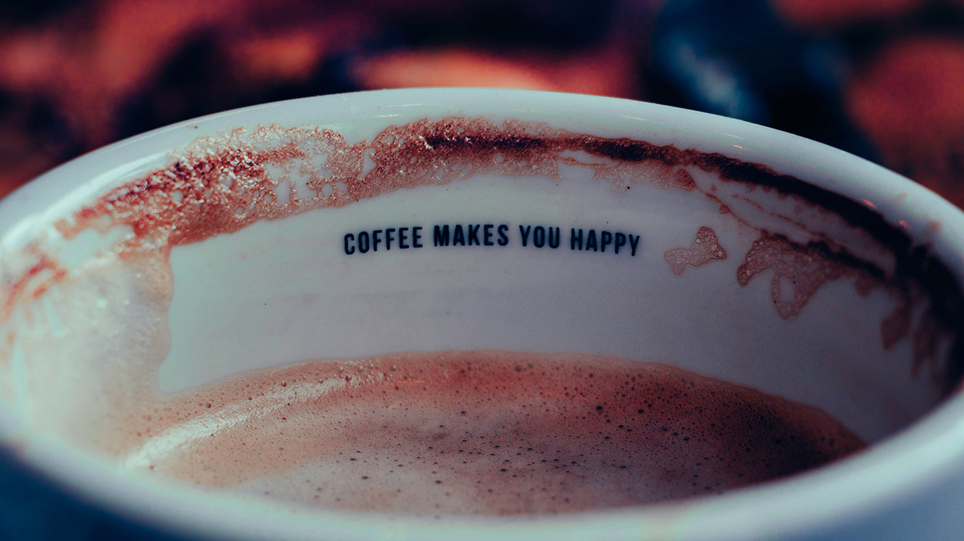 Eine Makroaufnahme einer Kaffeetasse der Kaffeerösterei Martermühle mit der Aufschrift "Coffee makes you happy"