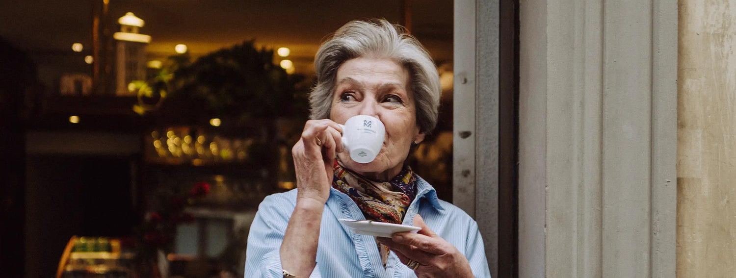Eine ältere Frau aus Italien die eine Espressotasse der Kaffeerösterei Martermühle zum Mund führt