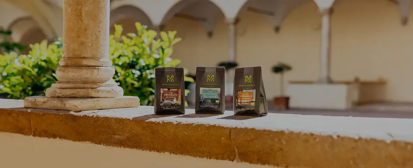 Drei Tüten Bio Espresso der Kaffeerösterei Martermühle auf einer Steinmauer in Italien