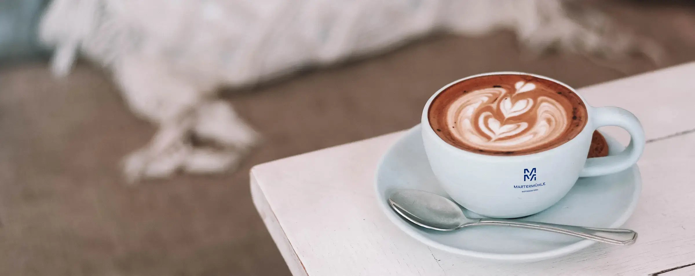 Eine Nahaufnahme einer Cappuccino Tasse der Kaffeerösterei Martermühle mit Latte Art 