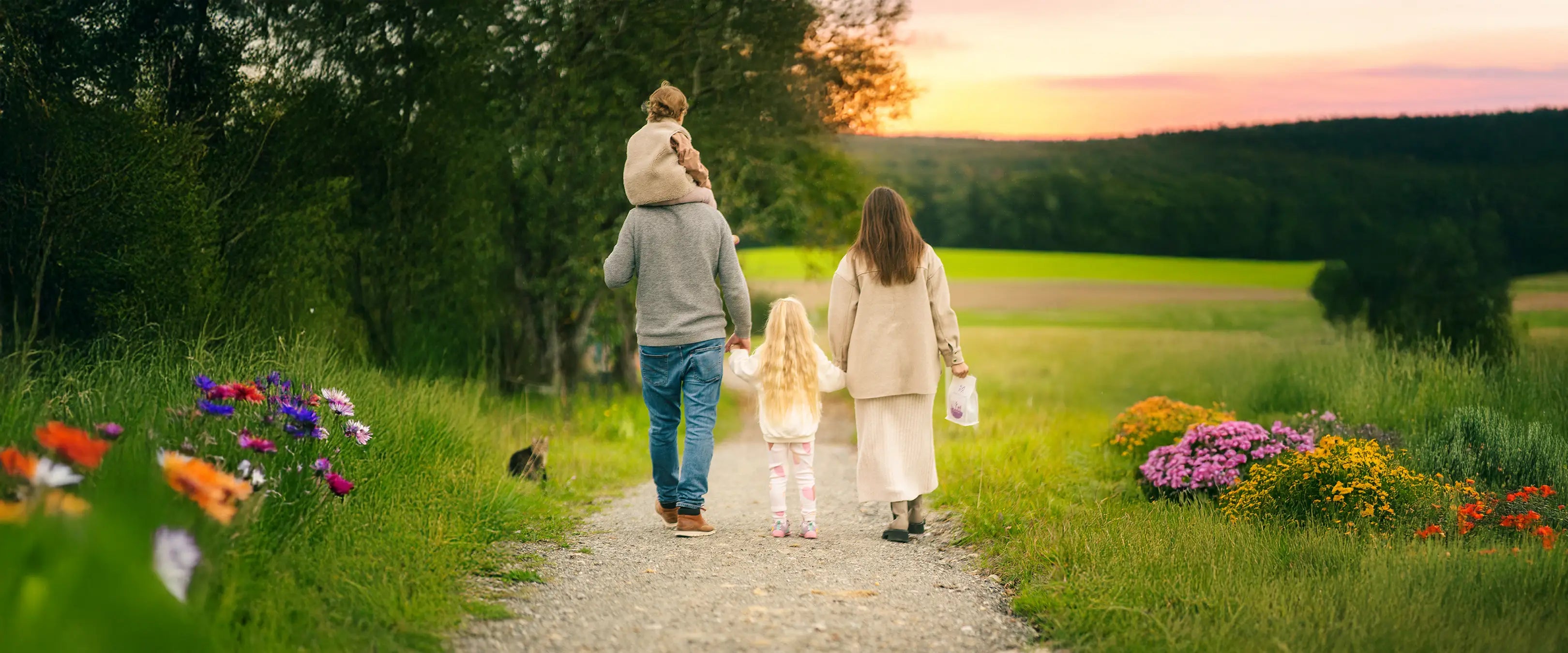 Familie in der Natur beim Sonnenuntergang im Frühling.